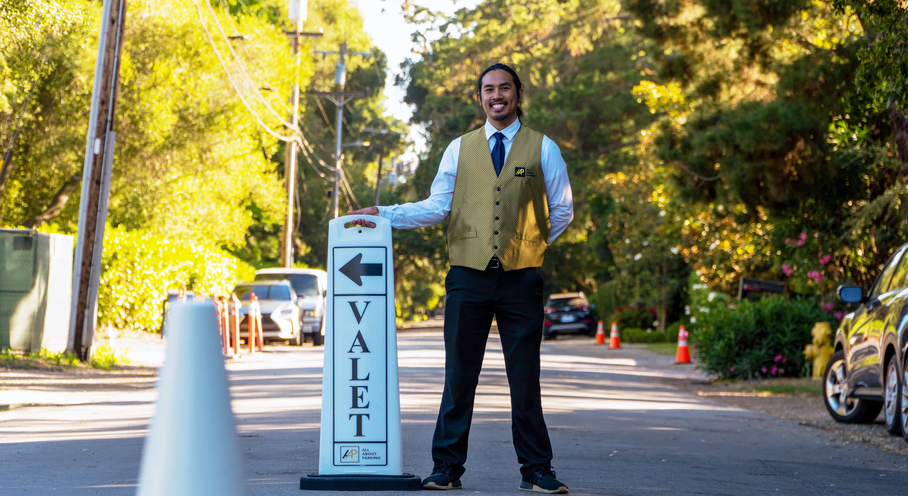 Valet attendant with valet sign at an outdoor event