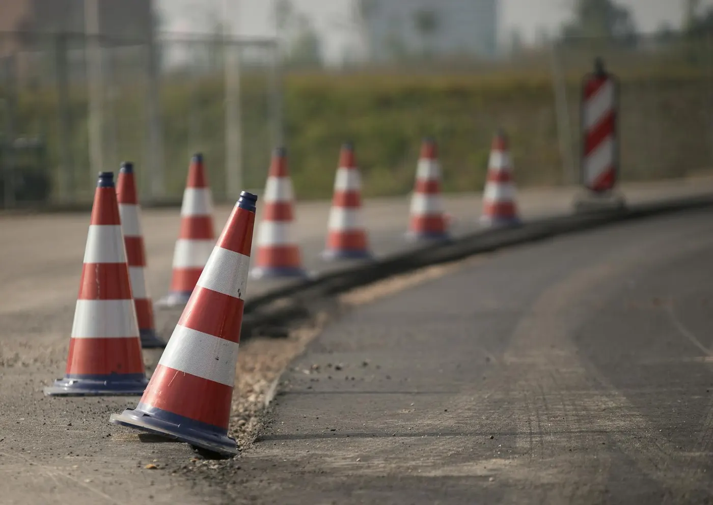 Row of orange and white traffic control cones along a construction-zone roadway
