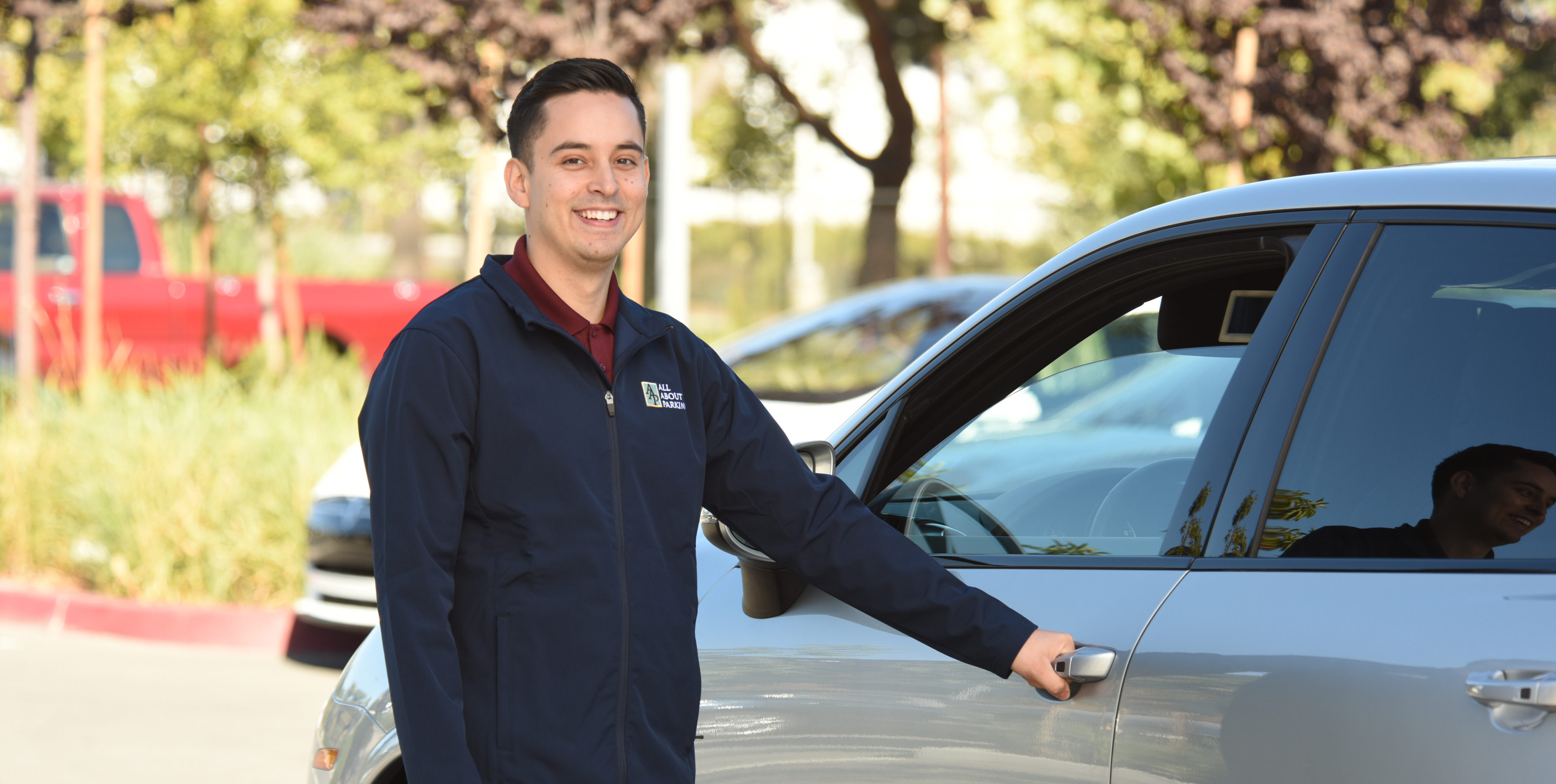 Smiling valet attendant opening a car door for a guest